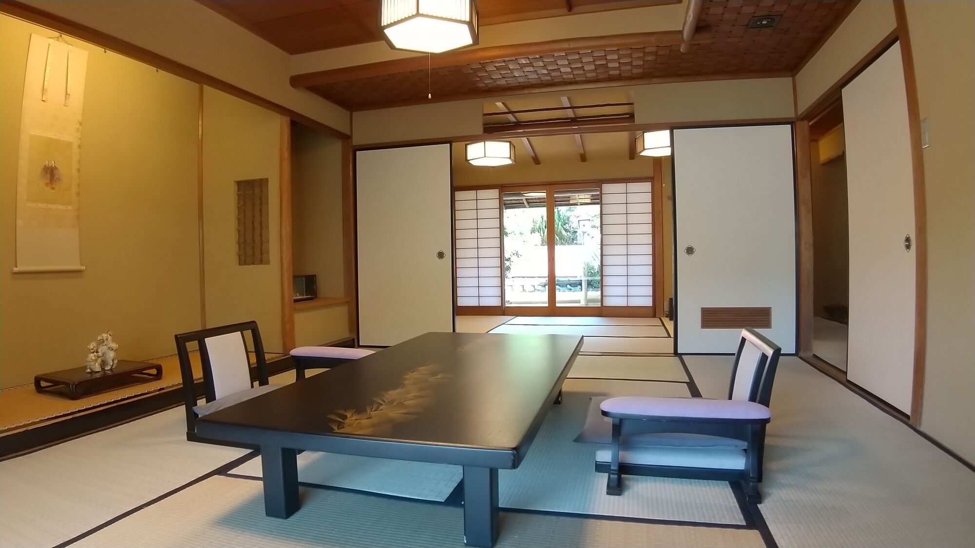 A traditional Japanese room with tatami flooring, a low table, and sliding doors.