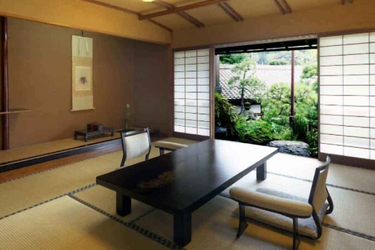 Um quarto japonês tradicional, com piso de tatame, uma mesa baixa e portas deslizantes.