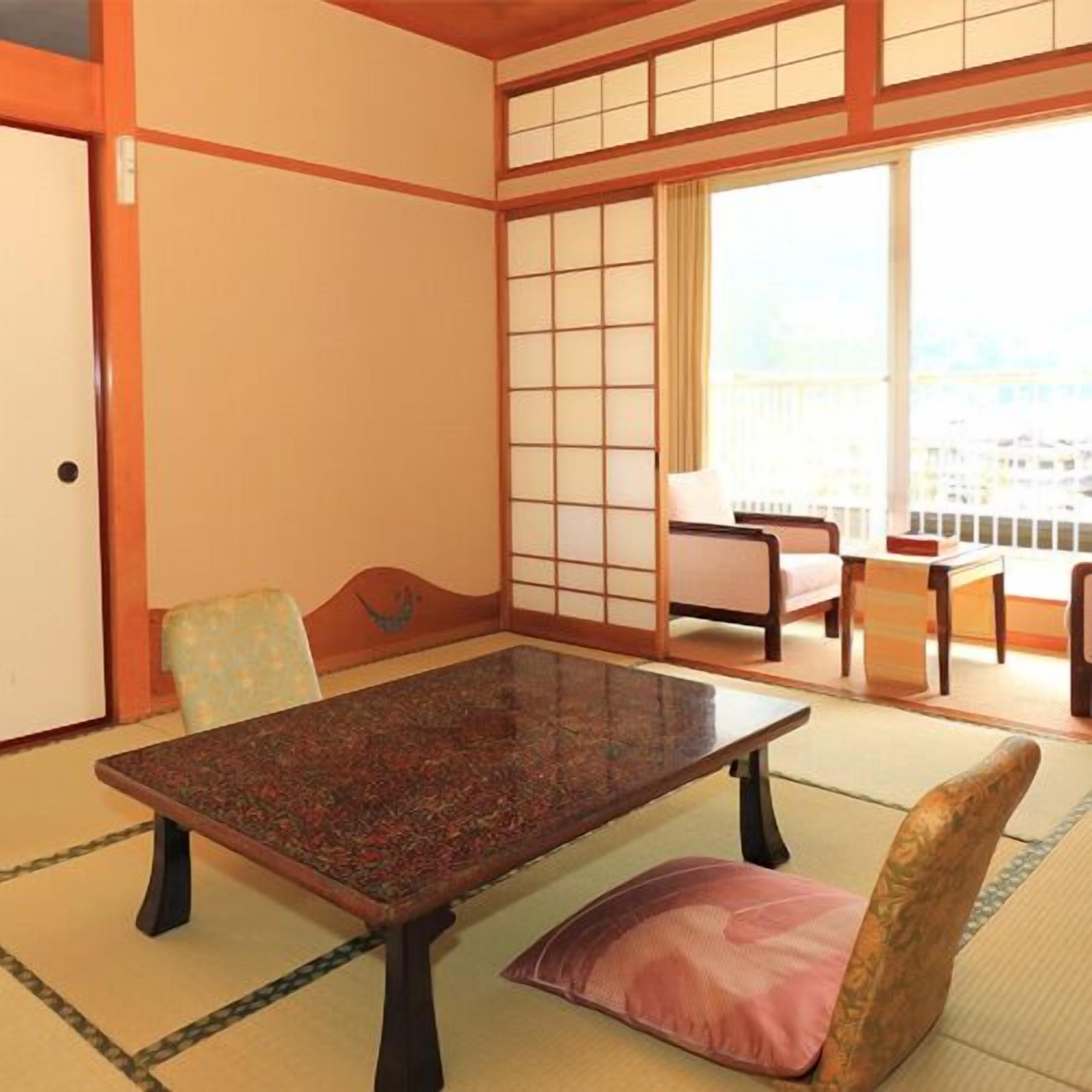 Een traditionele Japanse kamer met tatami vloerbedekking, een lage tafel en een schuifdeur.