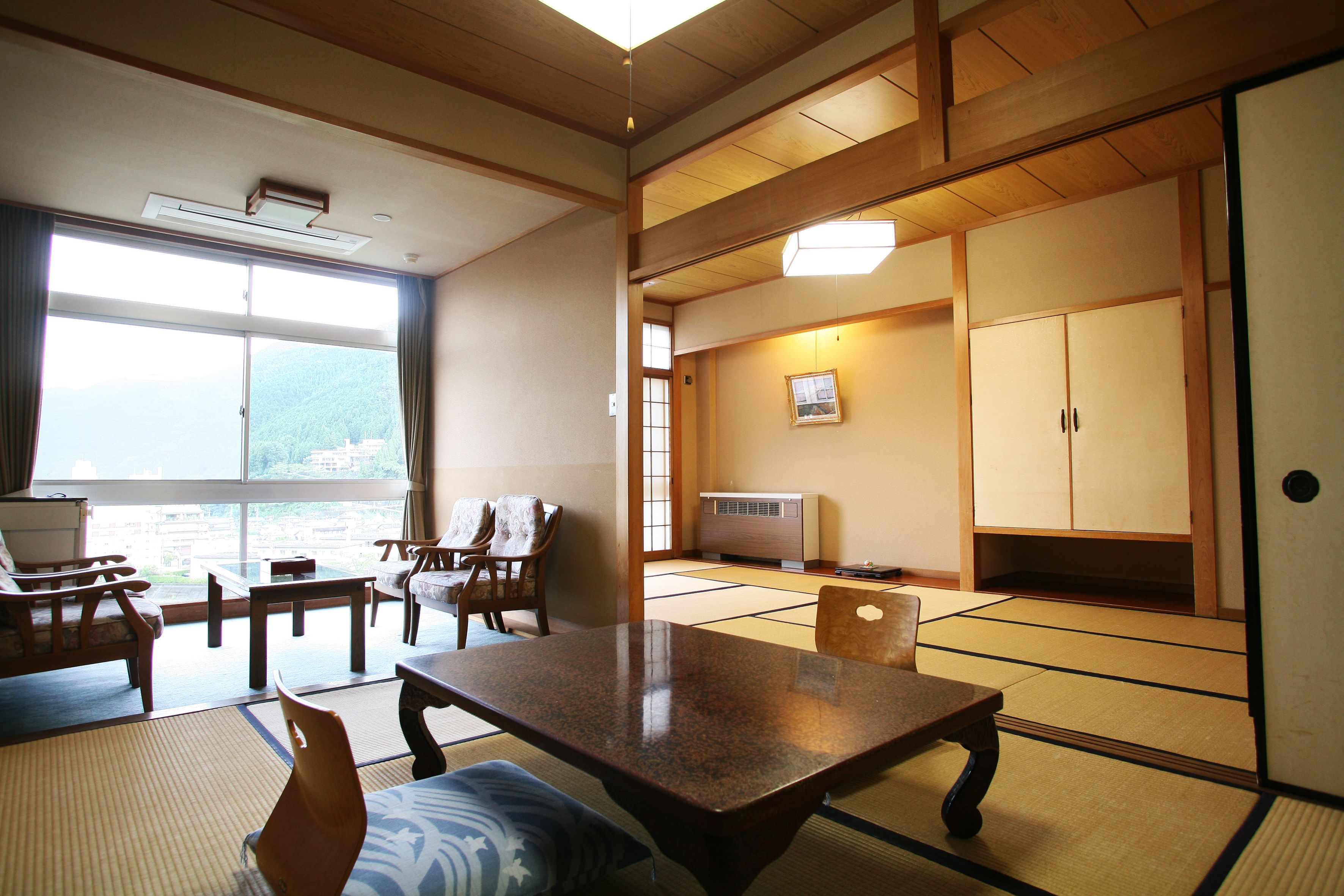 A traditional Japanese room with tatami flooring, a low table, and wooden furniture.