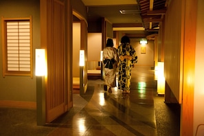 A corridor with traditional wooden doors and a tiled floor. - Gero Onsen Bosenkan (Gero)