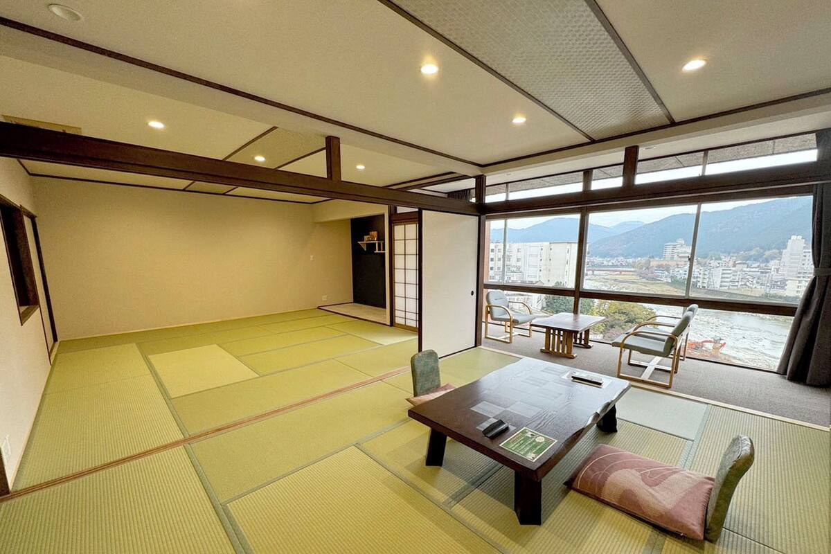 Una habitación con tatami que ofrece vistas a la ciudad y a las montañas.