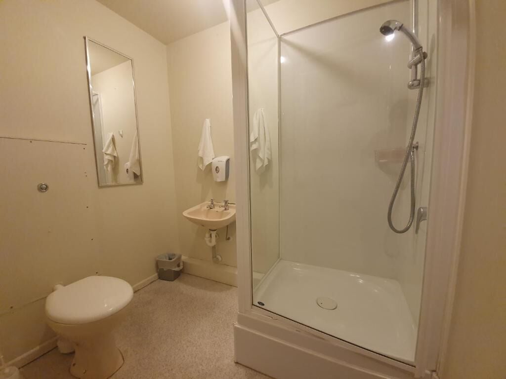 A bathroom with a toilet, sink, and glass-enclosed shower.