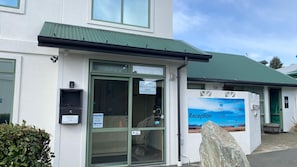 L’accueil d’un hôtel doté d’un toit végétalisé, avec un grand rocher à l’extérieur et un panneau indiquant qu’il n’y a plus de chambres disponibles, que ce soit des suites, des studios, des appartements de luxe ou des chambres pour les voyageurs à petit budget.