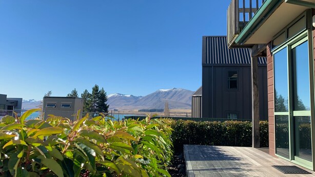 Un bâtiment moderne doté de grandes fenêtres et offrant une vue sur les montagnes.