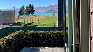Une vue depuis un balcon donnant sur un lac, avec des montagnes en arrière-plan.