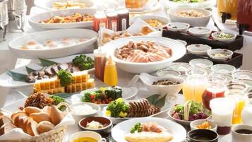 A buffet spread with various dishes, including meats, salads, and beverages.