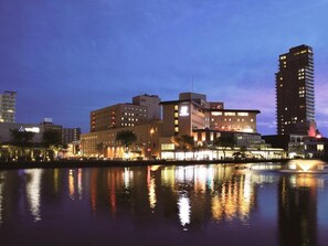 A waterfront hotel with multiple buildings, a reflection in the water, and a night sky. - Akita Castle Hotel (Akita)