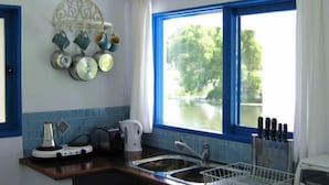 A kitchen with a window, a sink, and a kettle. - Spicy Oasis (Curramore)