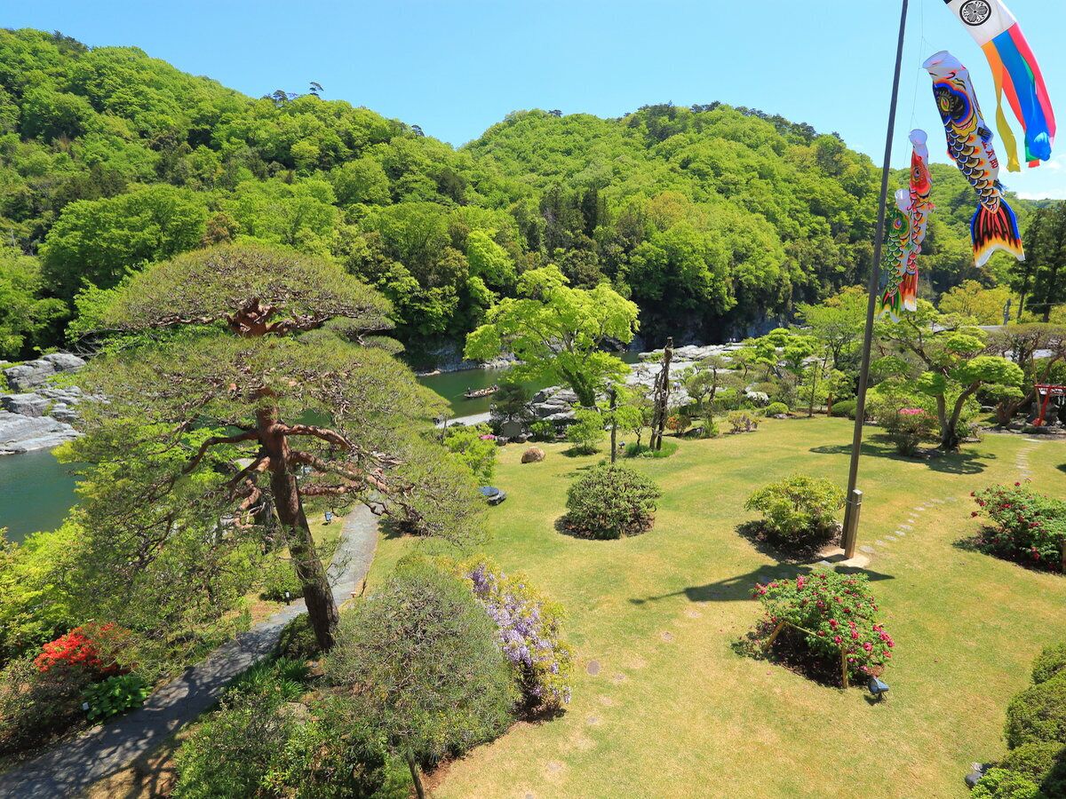 Un jardín ajardinado con senderos, árboles y decoraciones de peces koi.