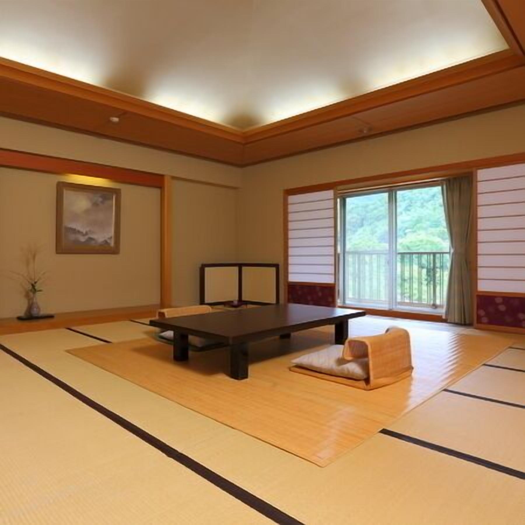 Ein Raum mit Tatami-Matten, einem niedrigen Tisch, einem Kissen und einem Gemälde an der Wand.