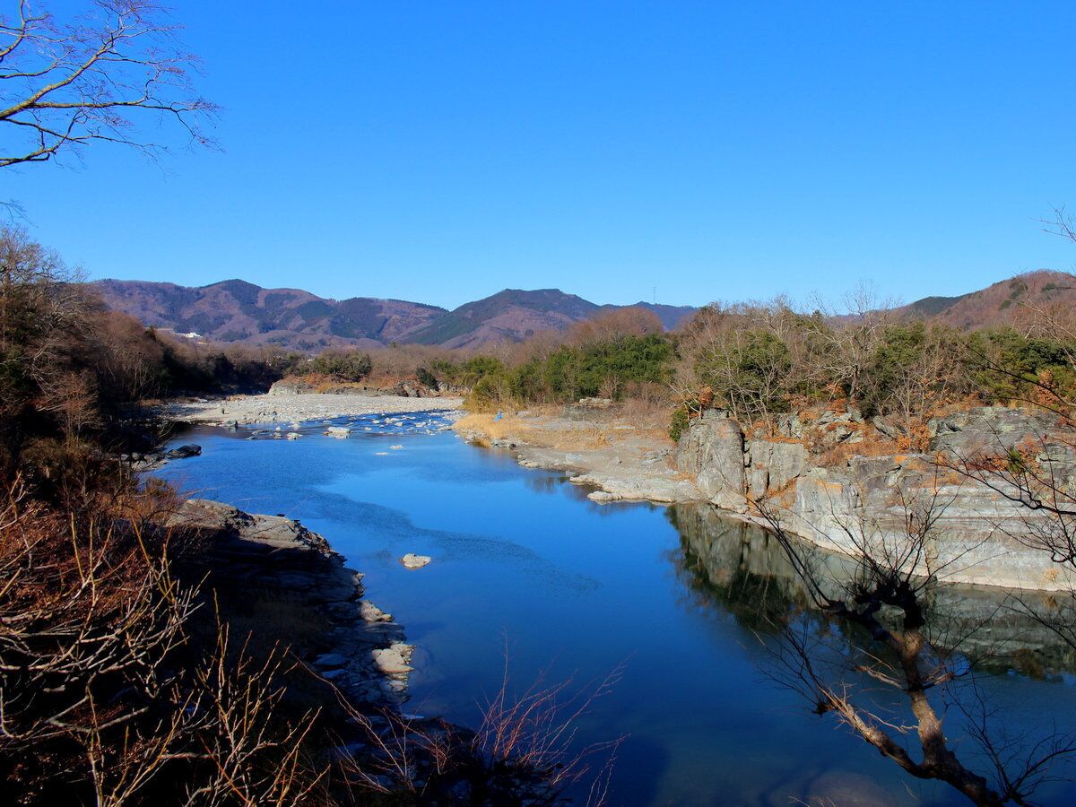 A river with rocky banks and mountains in the background.