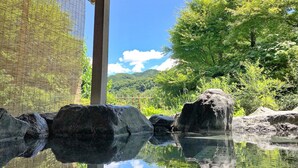 A serene outdoor setting with a wooden structure, a clear sky, and lush greenery. - Hana no Omotenashi Chosei Kan (Nagatoro)