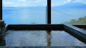A spa area with a large window overlooking a body of water and mountains. - Umi No Hotel Isaba (Numazu)