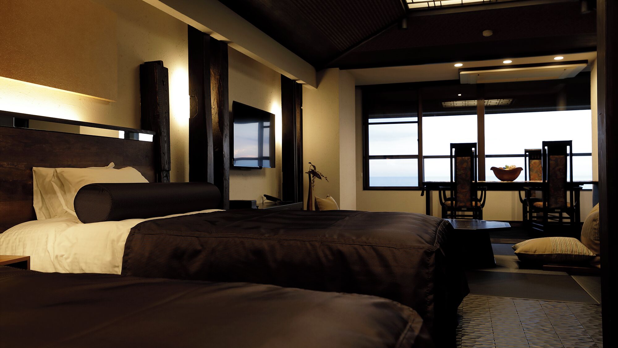A modern hotel room with a large bed, a desk, and a view of the outdoors.