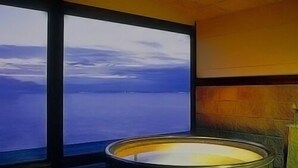 A room with a large window, a bathtub, and a wooden ceiling. - Umi No Hotel Isaba (Numazu)