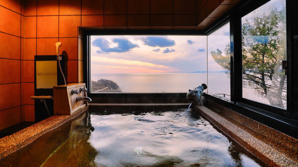Un jacuzzi con vistas al mar, un banco de madera y un perchero.