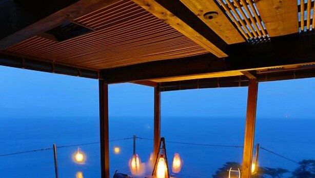 A spa area with a wooden ceiling, large windows, and a hot tub. - Umi No Hotel Isaba (Numazu)