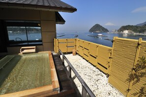 A traditional Japanese onsen with a wooden deck, a bamboo fence, and a view of the sea and mountains. - Izu Mitsuhama Syoutoukan (Numazu)
