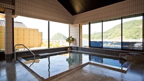 A modern indoor swimming pool with clear views of a mountainous landscape through large windows. - Izu Mitsuhama Syoutoukan (Numazu)