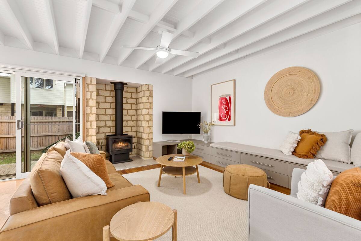 A modern living room with a fireplace, a TV, and comfortable seating.