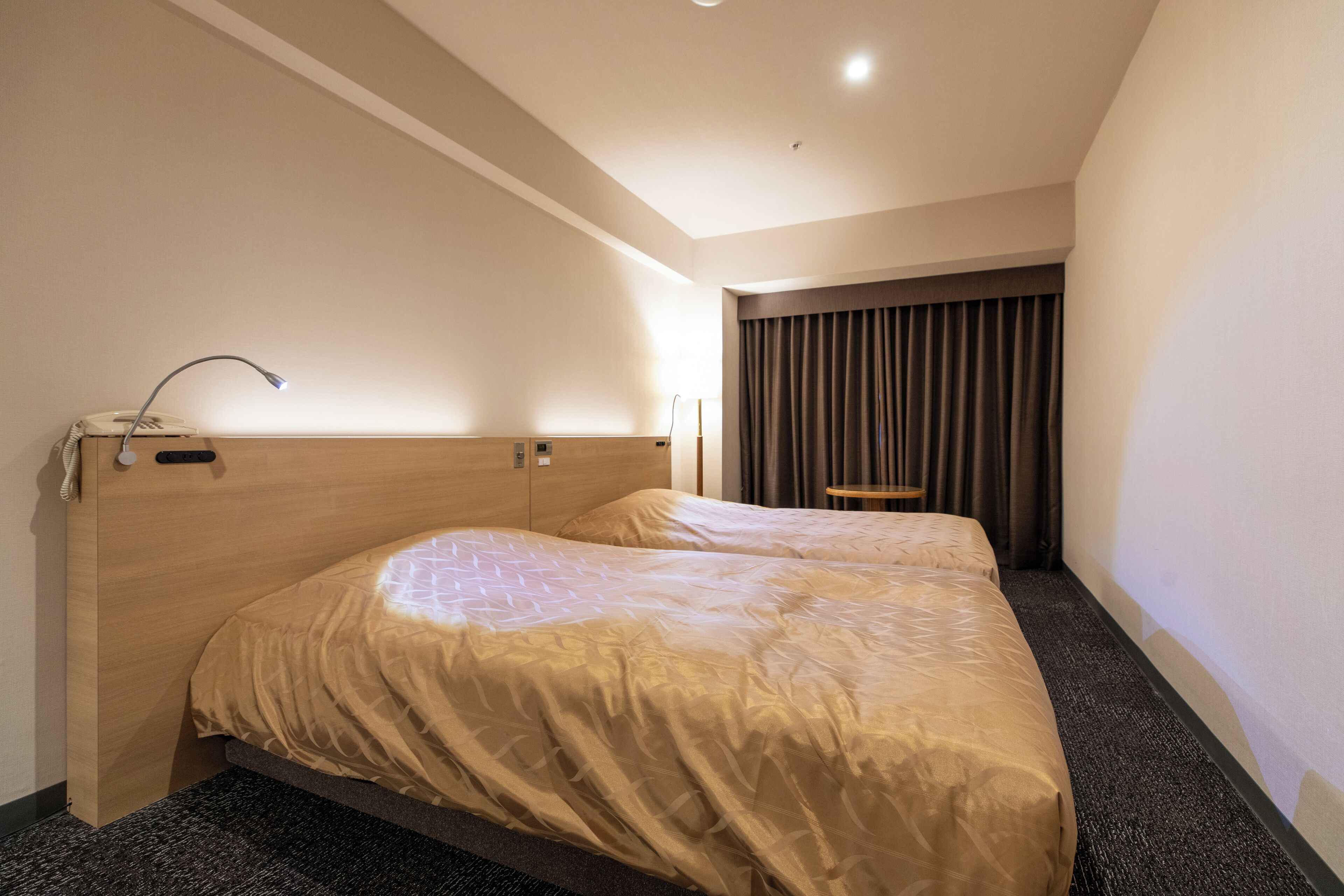 A hotel room with a large bed, a desk, and a chair.