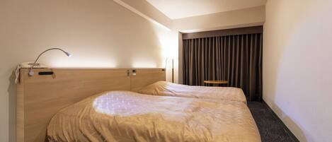 A hotel room with a large bed, a desk, and a chair.