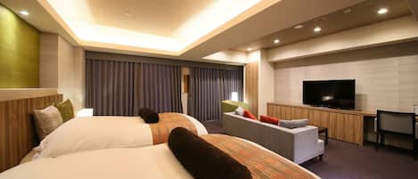 Una habitación de hotel moderna con dos camas grandes, un sofá, un televisor y un escritorio.