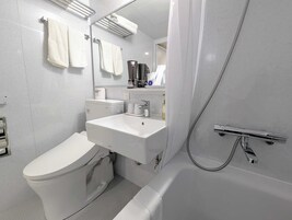 Un baño moderno con inodoro, lavamanos y ducha.