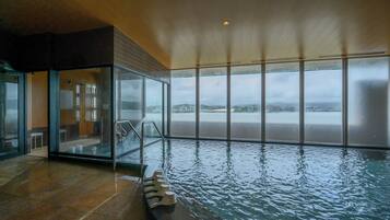 Swim and take in the city views from our indoor pool area, surrounded by large windows and steps leading in.