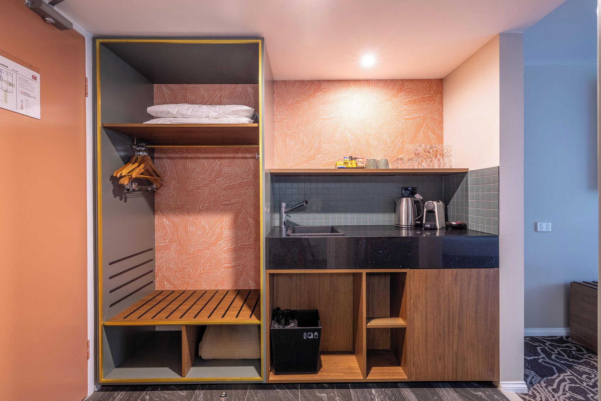 Una kitchenette compacta con un lavabo, una cafetera y una pequeña encimera.