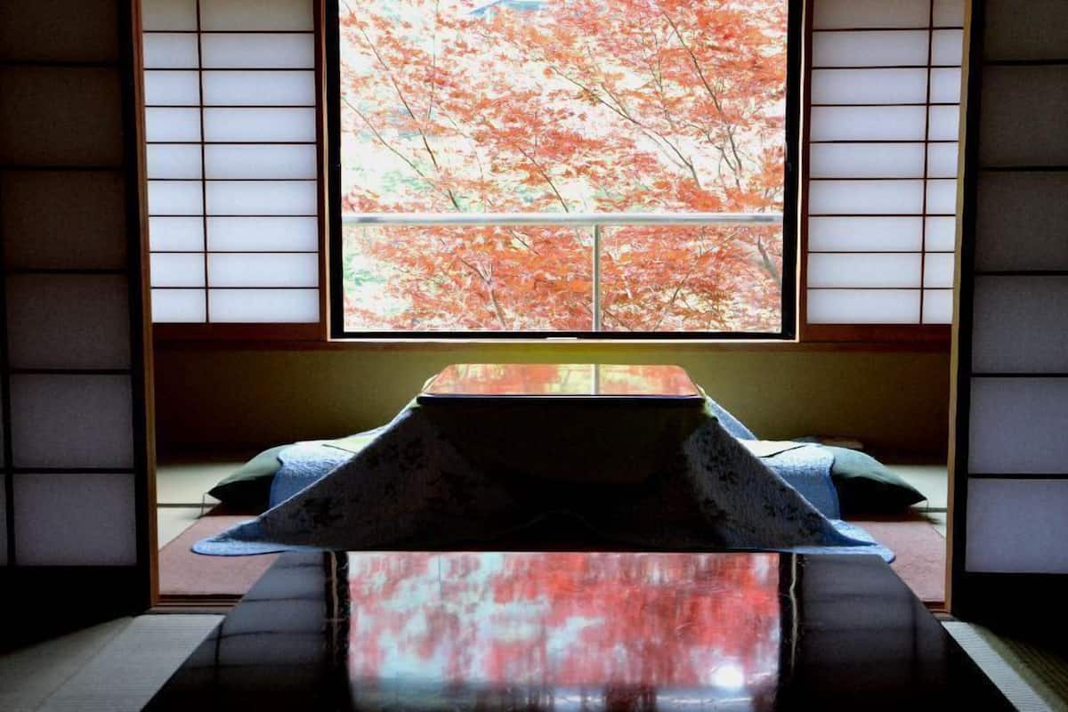 A traditional Japanese room with tatami flooring, a low table, and shoji screens.