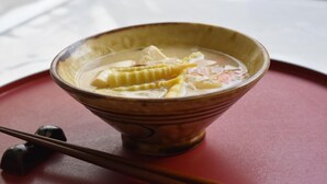 A bowl of food on a red surface with chopsticks beside it. - Uesugi Kenshinnokakushiyu Sekionsen Asahiya Ryokan (Myoko)