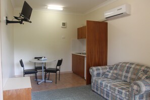 Habitación ejecutiva, 1 cama de matrimonio, cocina básica | Sala de estar | Una televisión LCD, un reproductor de DVD