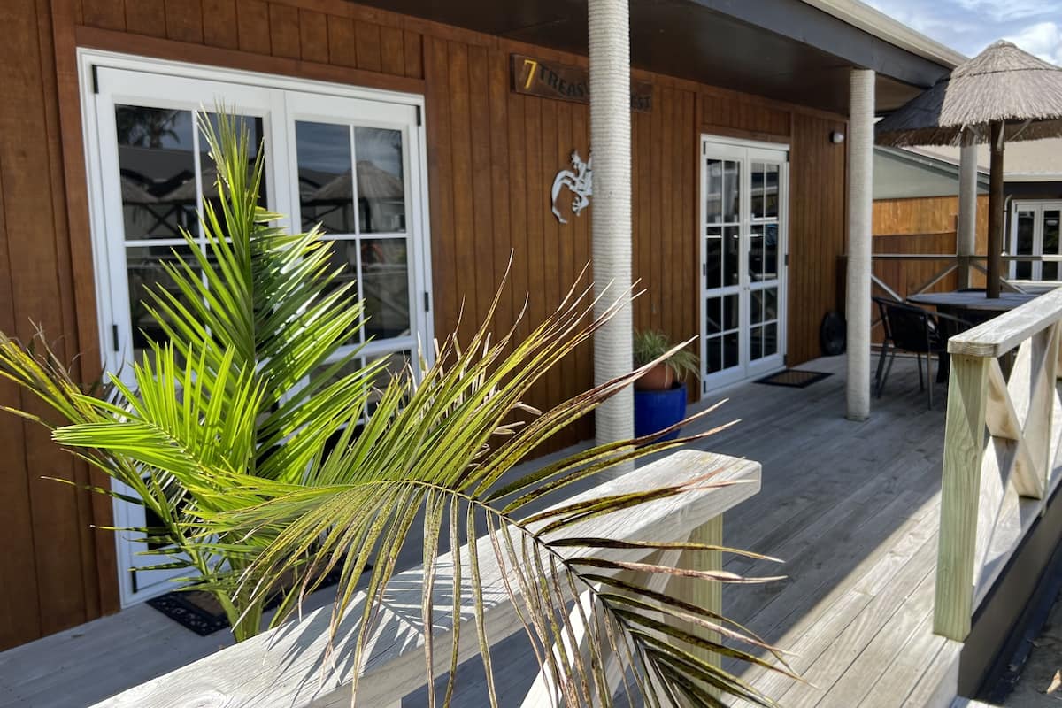 A wooden exterior with large windows and a covered patio area.
