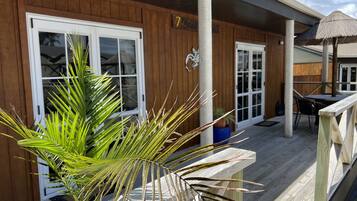 A wooden exterior with large windows and a covered patio area.