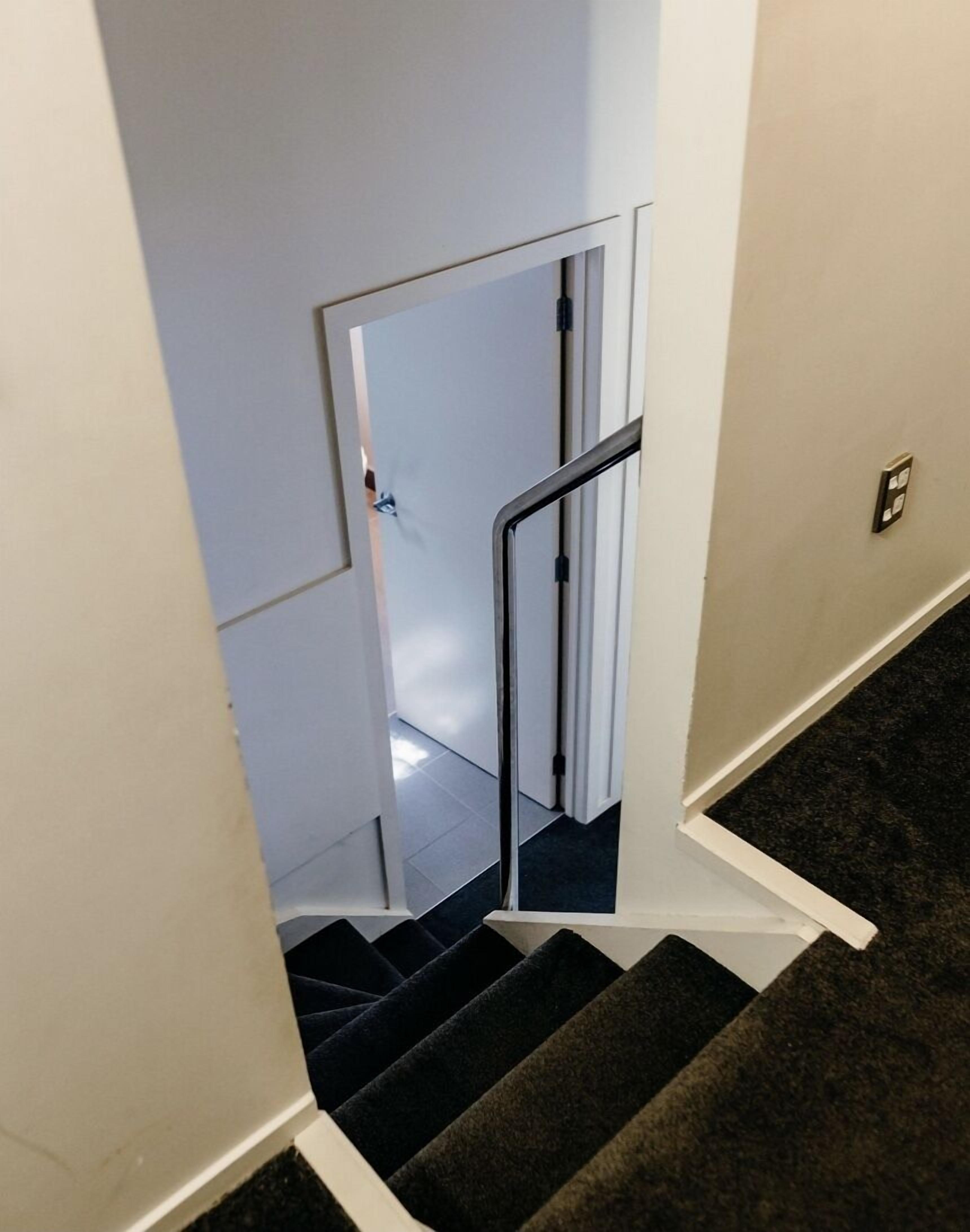 Una escalera con barandilla y peldaños alfombrados.