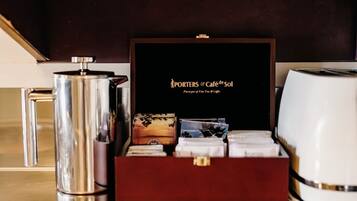 A coffee maker, a box with a coffee-themed design, and a coffee pot on a countertop.