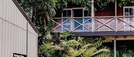 A building with a sign for 'Harbour View Suites' and a covered walkway with a view of the surrounding greenery.