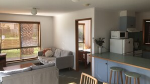 Une cuisine compacte comprenant un coin repas, un canapé et une petite table.