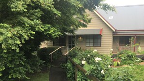 A pathway leading to a building with a sign labeled "OFFICE" on the door. - Neerim Country Cottages (Neerim South)