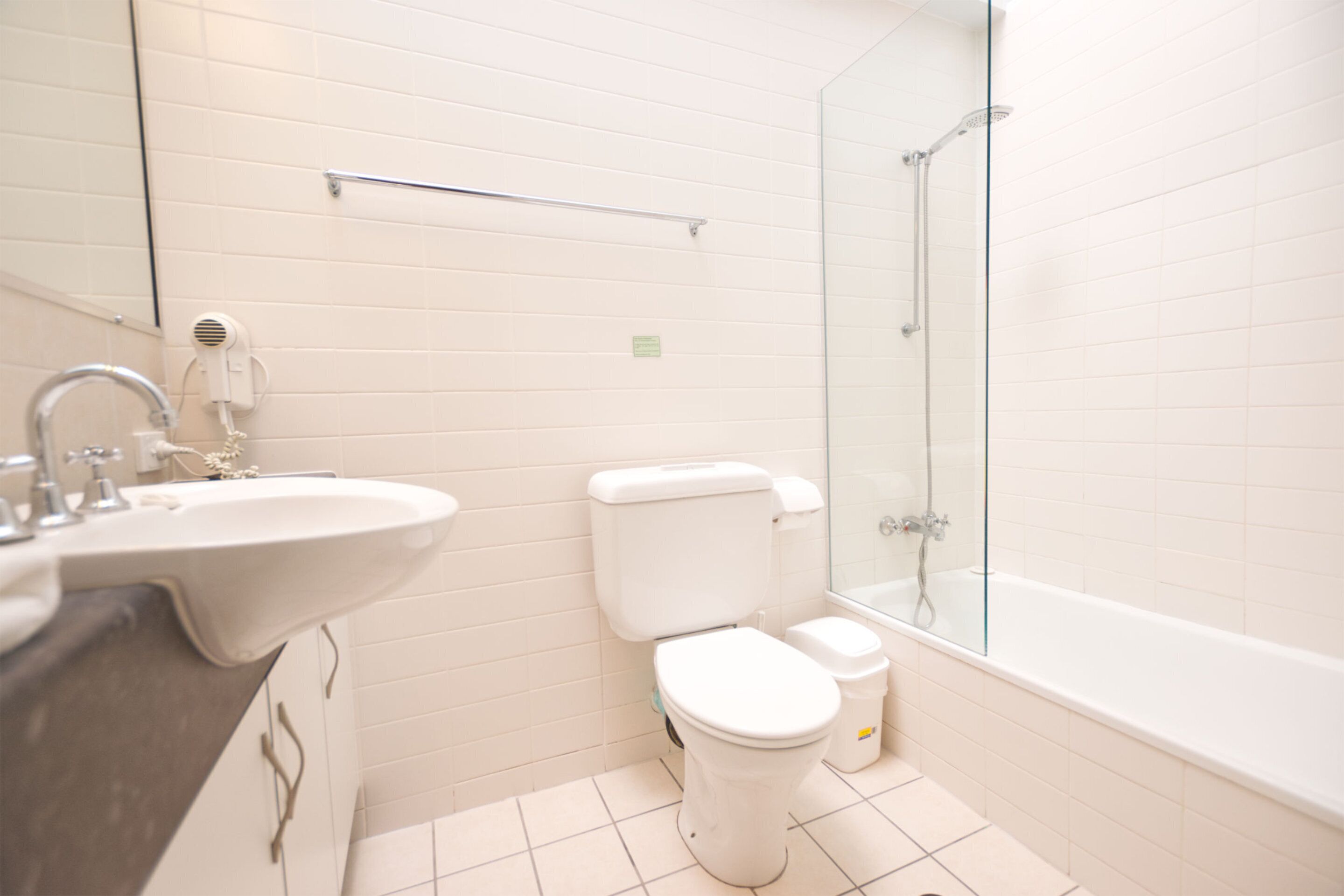 A modern bathroom with a sink, toilet, and glass-enclosed shower.