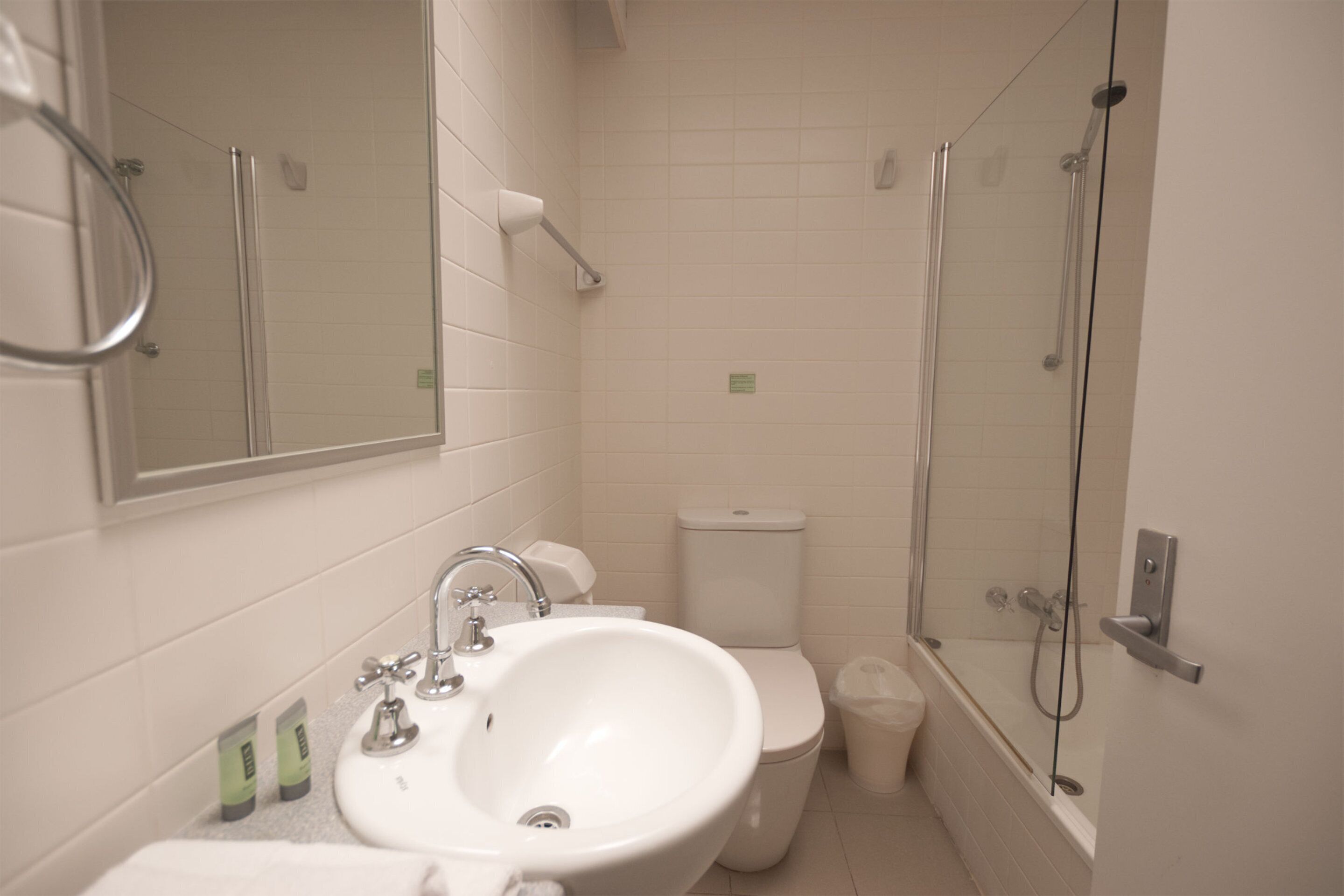 A bathroom with a sink, toilet, and glass-enclosed shower.