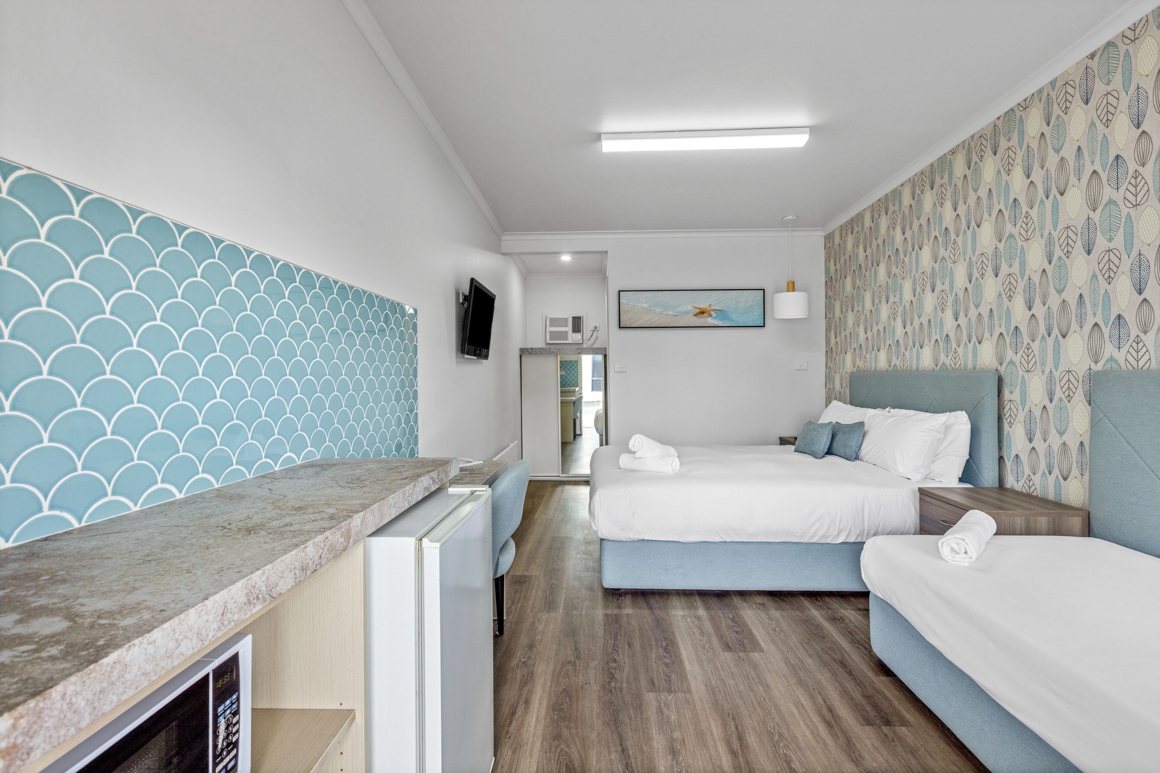 Ein Hotelzimmer mit einem Bett, einem Schreibtisch und einer Mikrowelle.