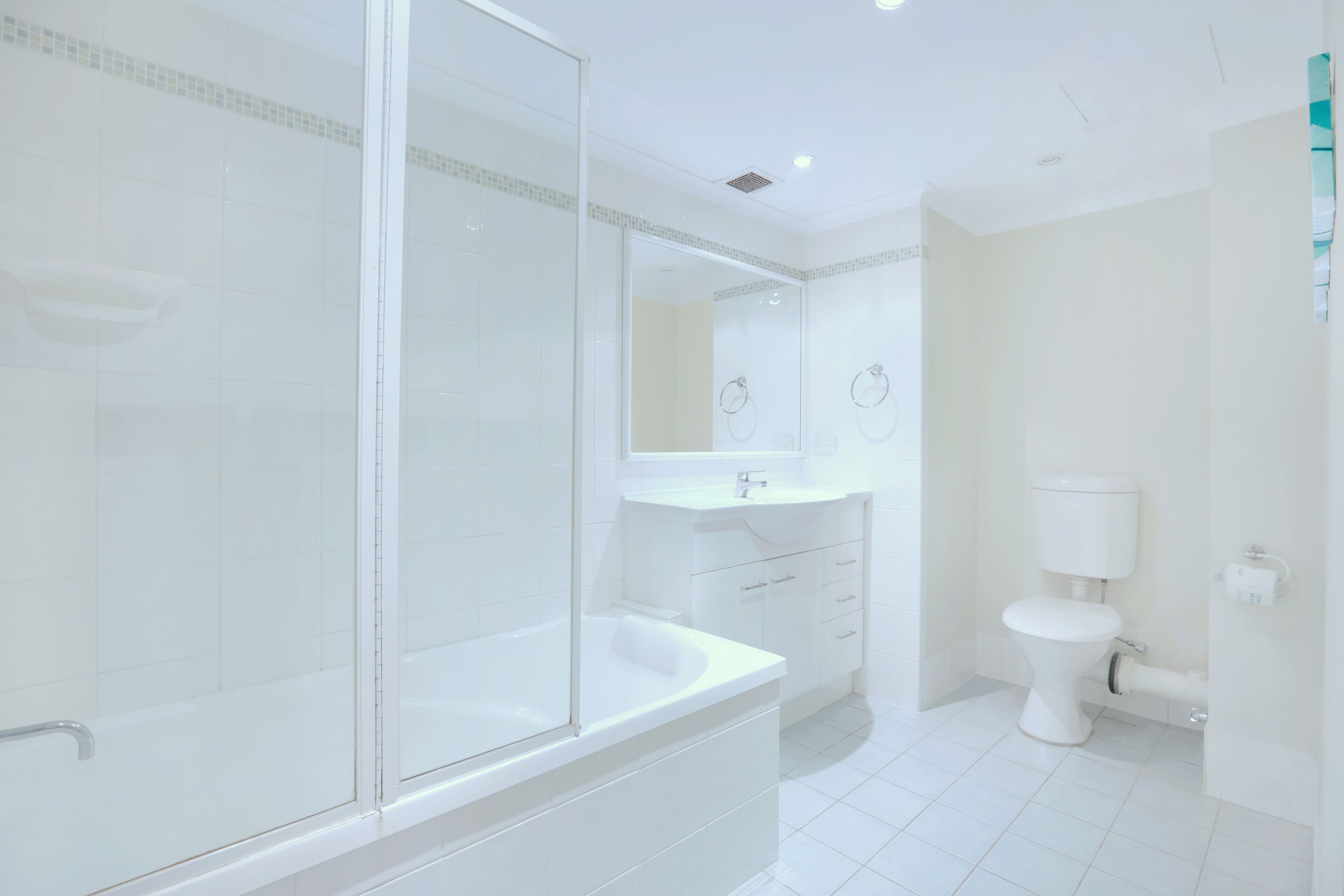 A modern bathroom with a glass-enclosed shower, a white bathtub, a sink, and a toilet.