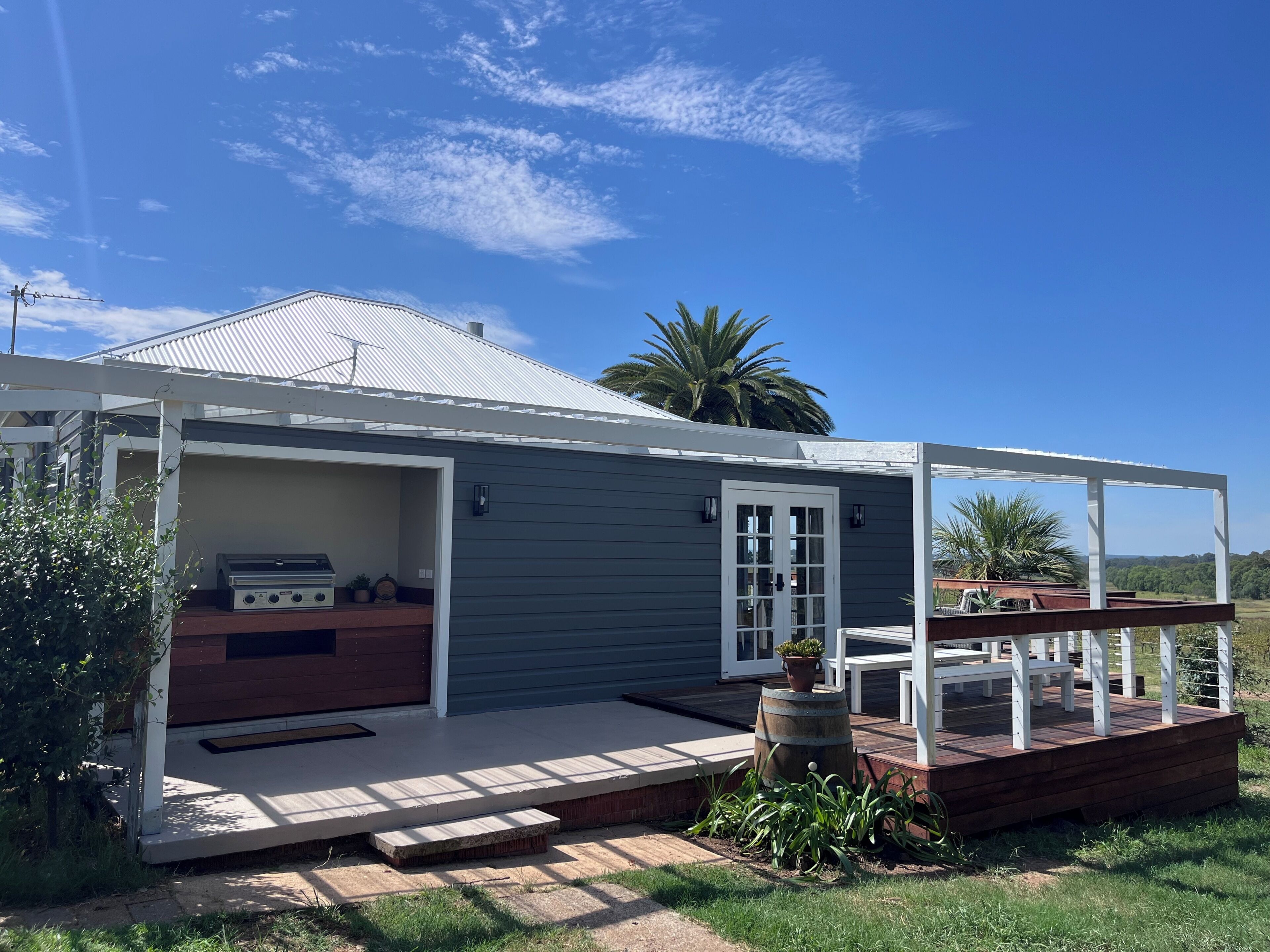 A house with a covered porch, a barbecue grill, and a small deck.