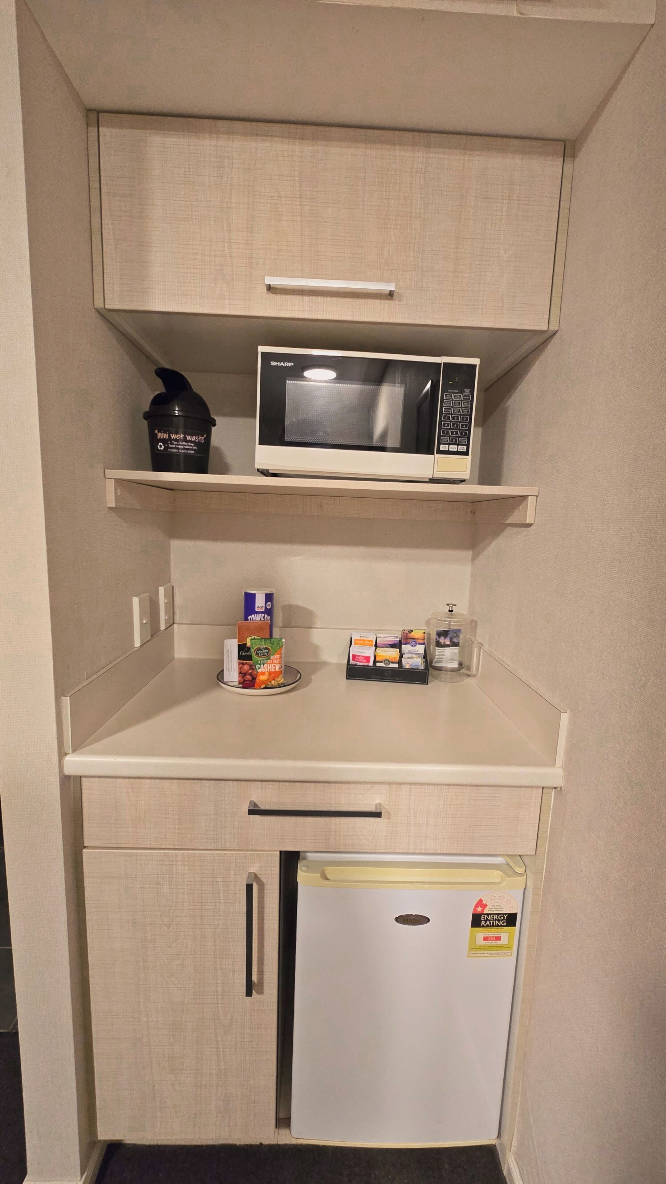A compact kitchenette with a microwave, a mini fridge, and a coffee machine.