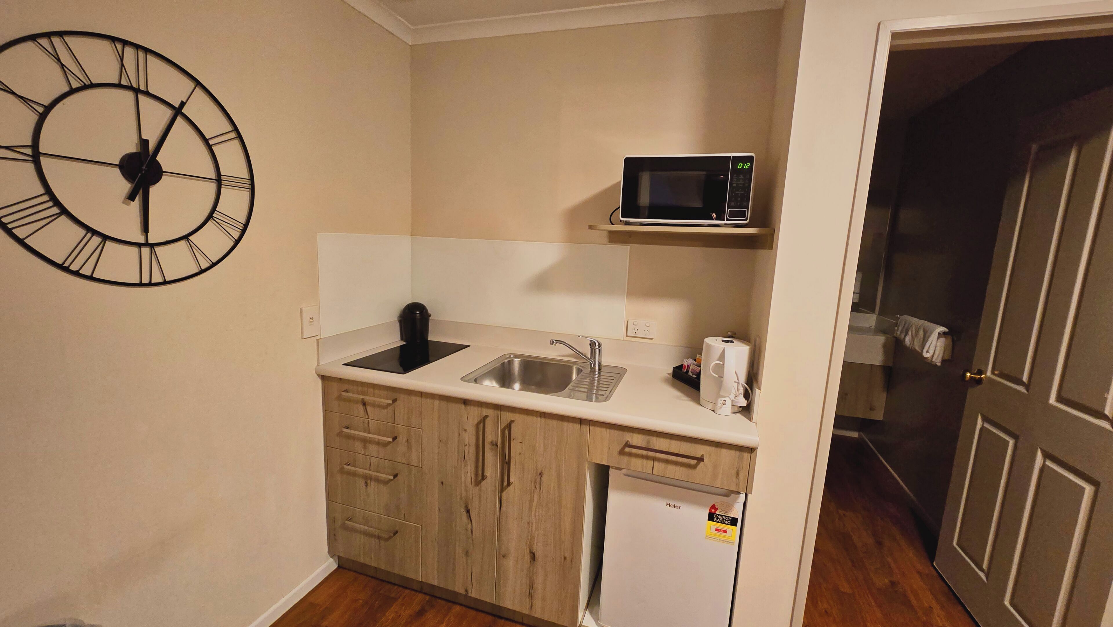 Cocina compacta con un lavamanos, microondas y refrigerador.