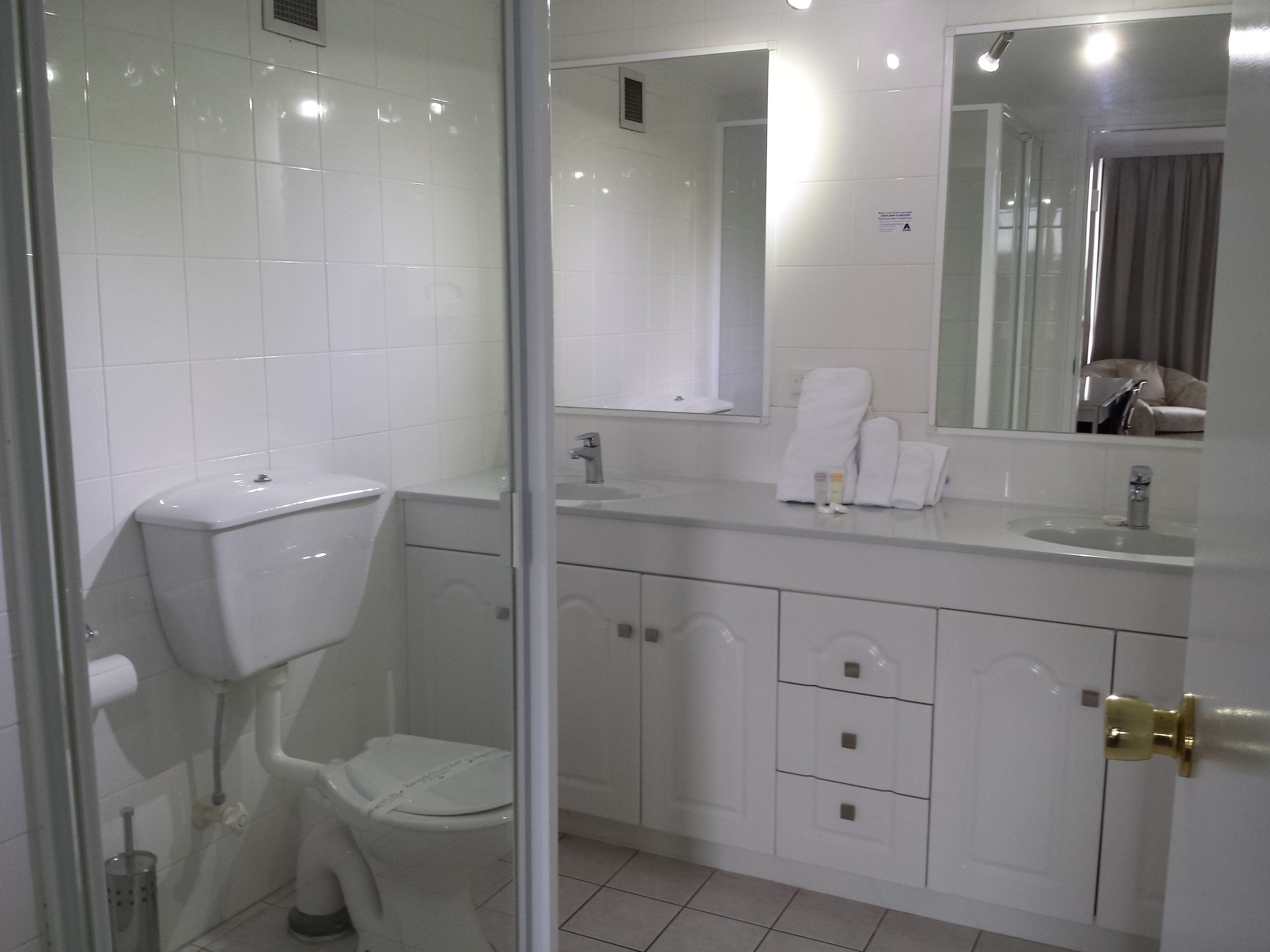 A modern bathroom with a toilet, sink, and mirror.