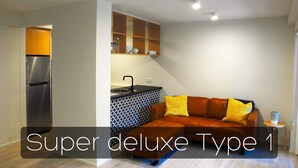 A modern living space with a kitchen, a sofa, and a small side table. - Montego Sands Resort (Mermaid Beach)